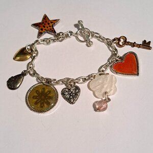 Silver tone charm bracelet with hearts, stars, tear drops, flowers and more